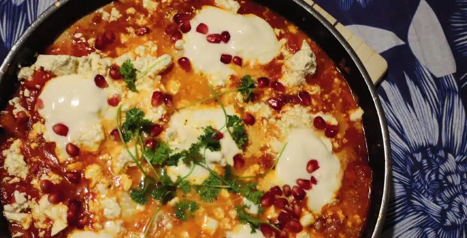 Shakshuka mit Feta, Joghurt und Granatapfelkernen in der Pfanne